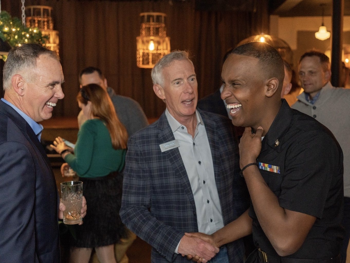 Dean Harrington shaking hands and laughing with two leaders